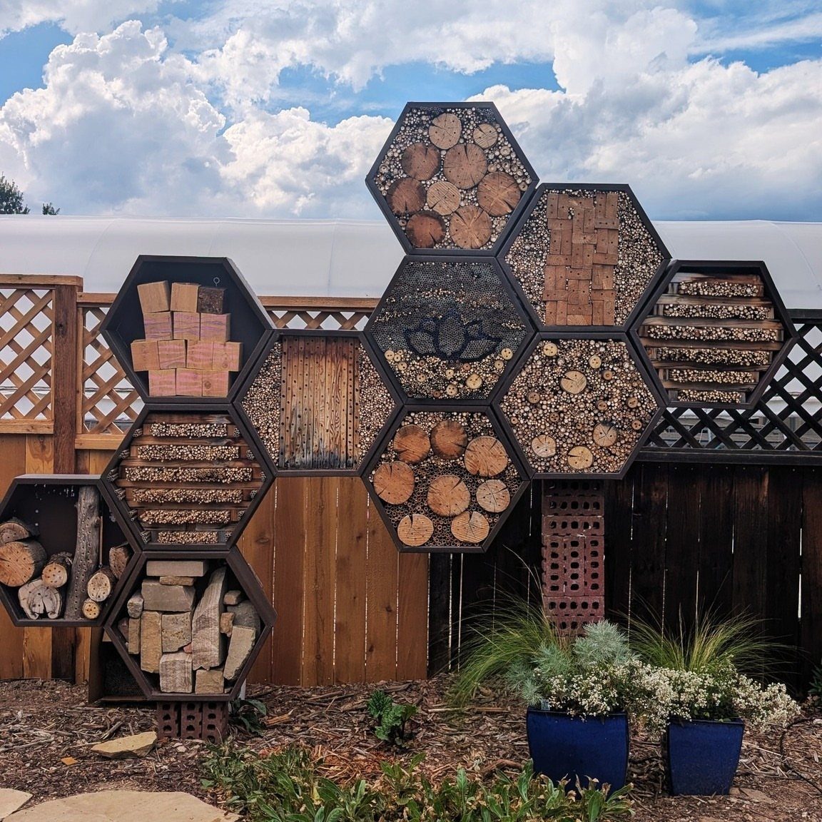 23 Backyard DIY Ideas for a Patio, Garden and Fire Pit 17 Honeycomb-shaped mason bee house filled with wood and bamboo against a wooden fence.