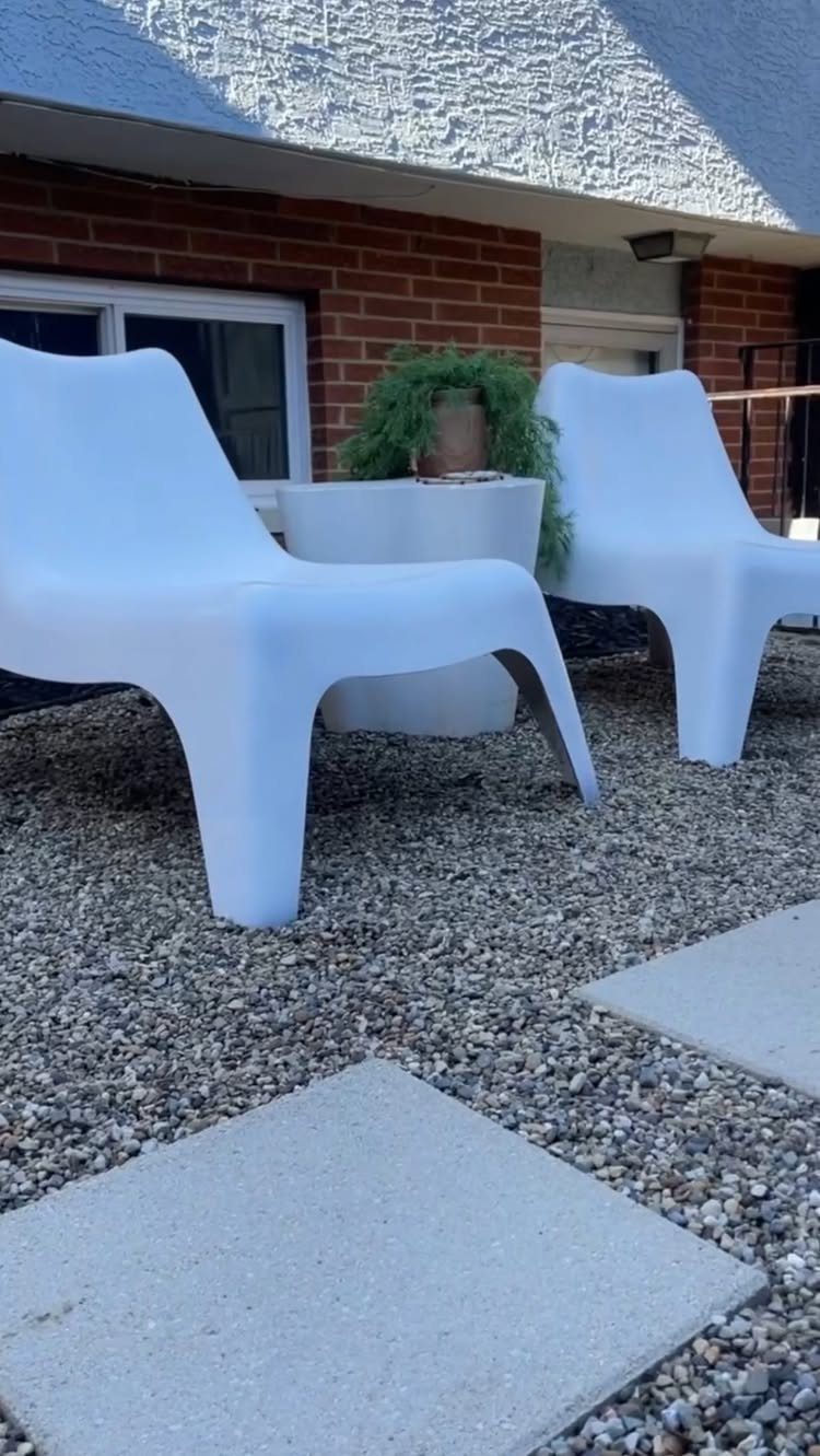 23 Backyard DIY Ideas for a Patio, Garden and Fire Pit 1 White lounge chairs and a table on a grey pea gravel patio with pavers.