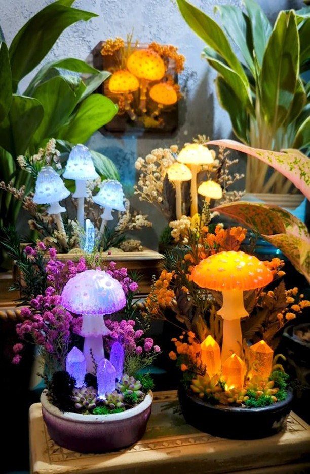 Glowing colorful LED mushroom lamps in small potted fairy garden arrangements with crystals.