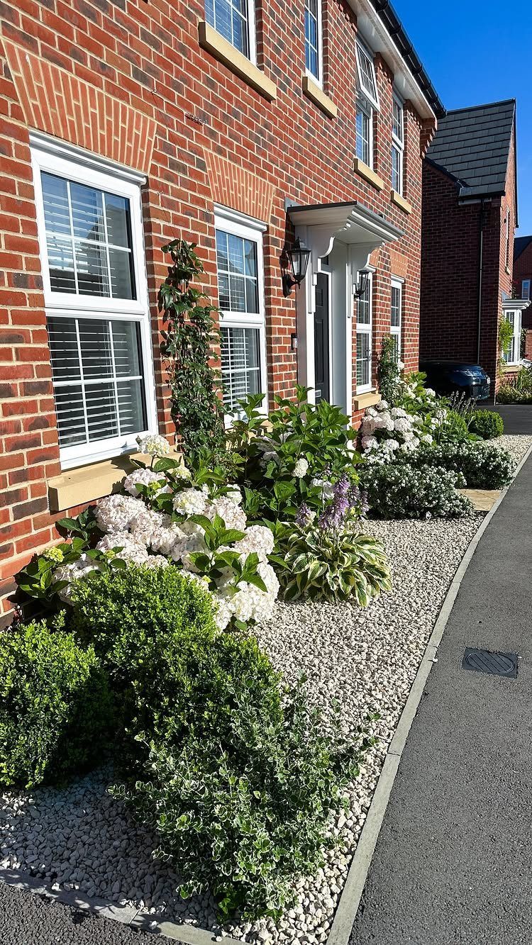 26 Front Garden Ideas for Curb Appeal and Small Yards 5 Narrow front garden with white hydrangeas and green shrubs in light gravel landscaping.