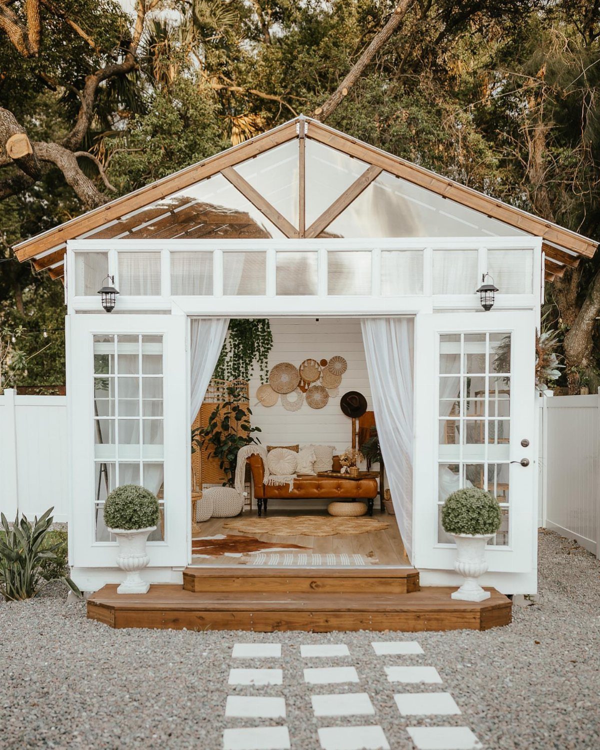 White greenhouse shed interior featuring a cozy lounge area with a brown sofa.