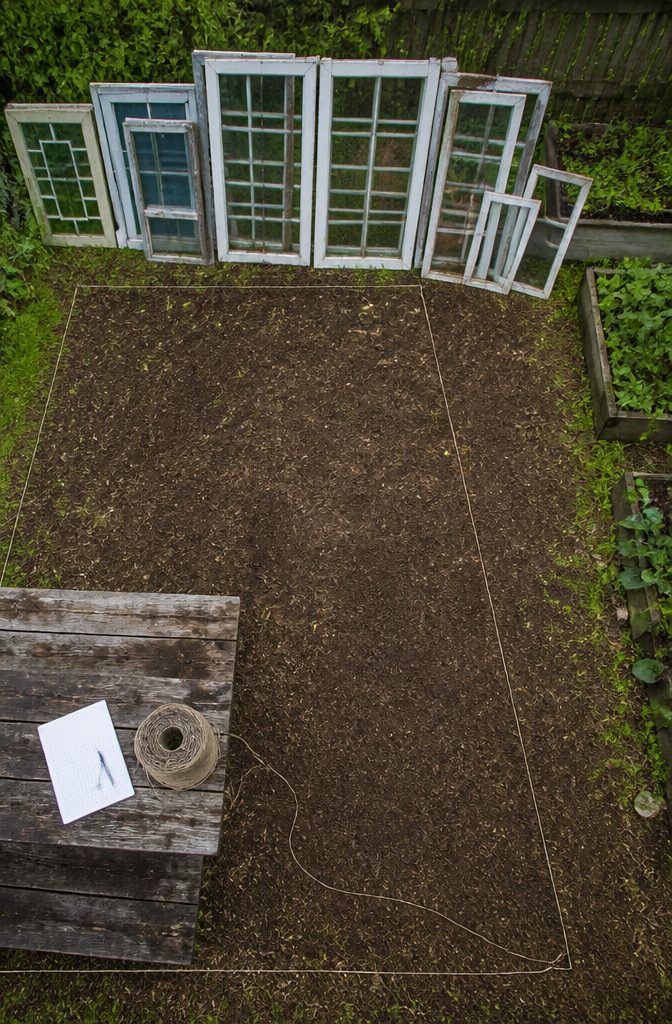Old windows gathered for a greenhouse build, with varied sash sizes