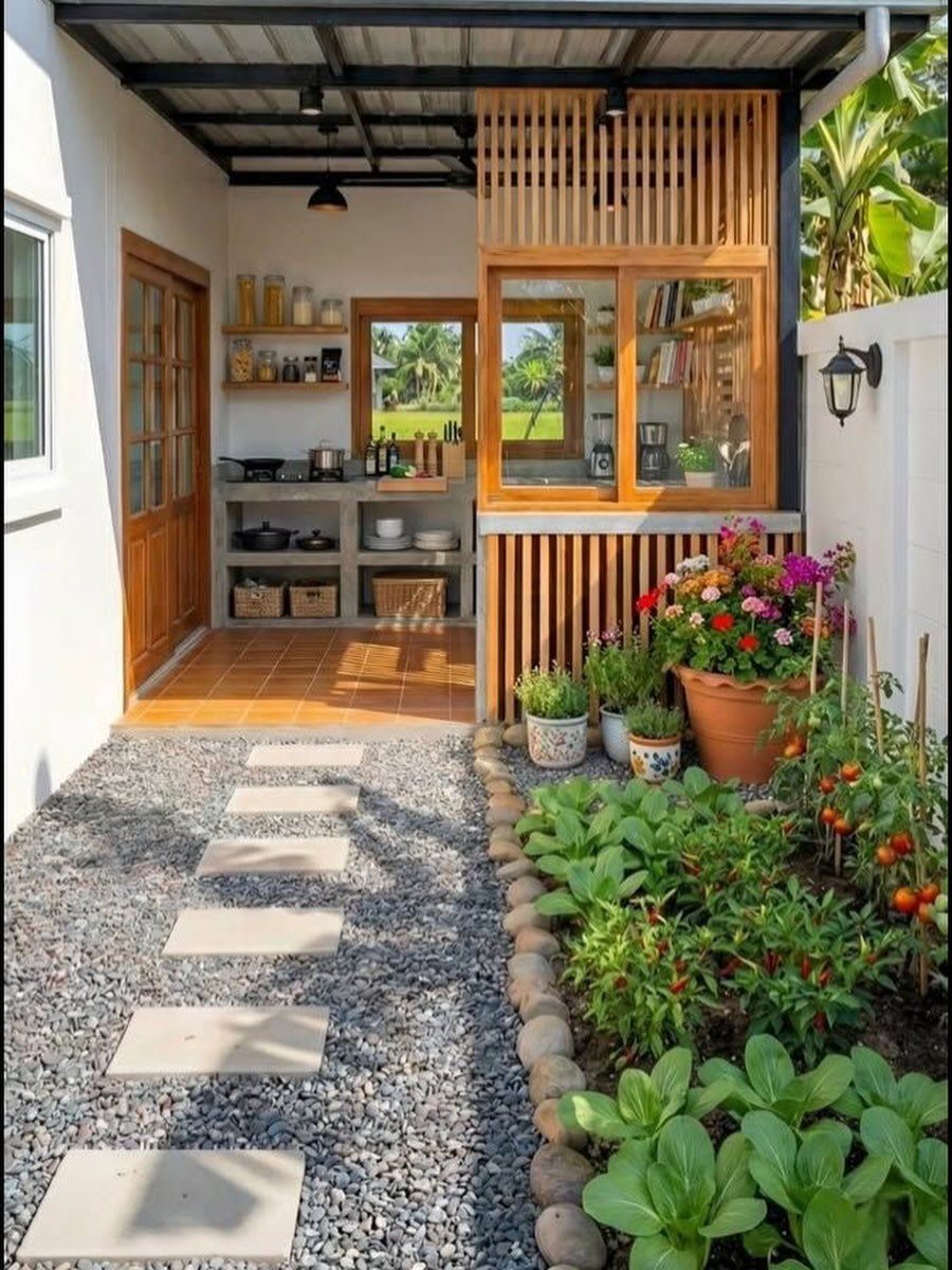 Gravel path with stepping stones leading to an outdoor kitchen and vegetable garden