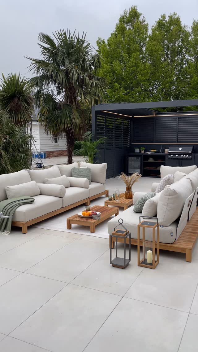 White outdoor sectionals with light green pillows on a grey tiled patio.