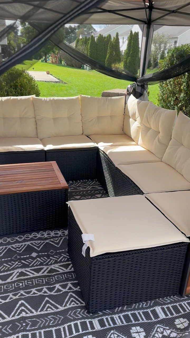 Outdoor Modular Seating: 20 Sectionals and Sofa Sets 7 Black wicker modular sectional with cream cushions on a patterned outdoor rug.