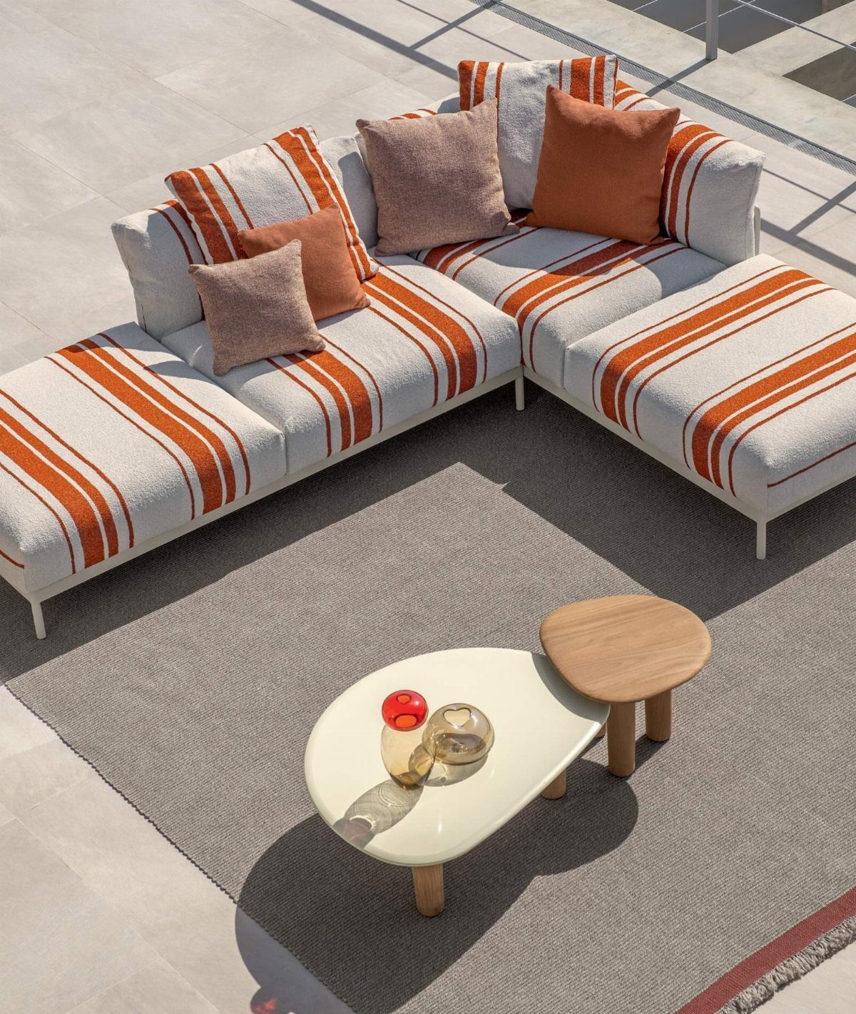 Outdoor Modular Seating: 20 Sectionals and Sofa Sets 1 Modular outdoor sofa with orange and white striped cushions on a grey rug.