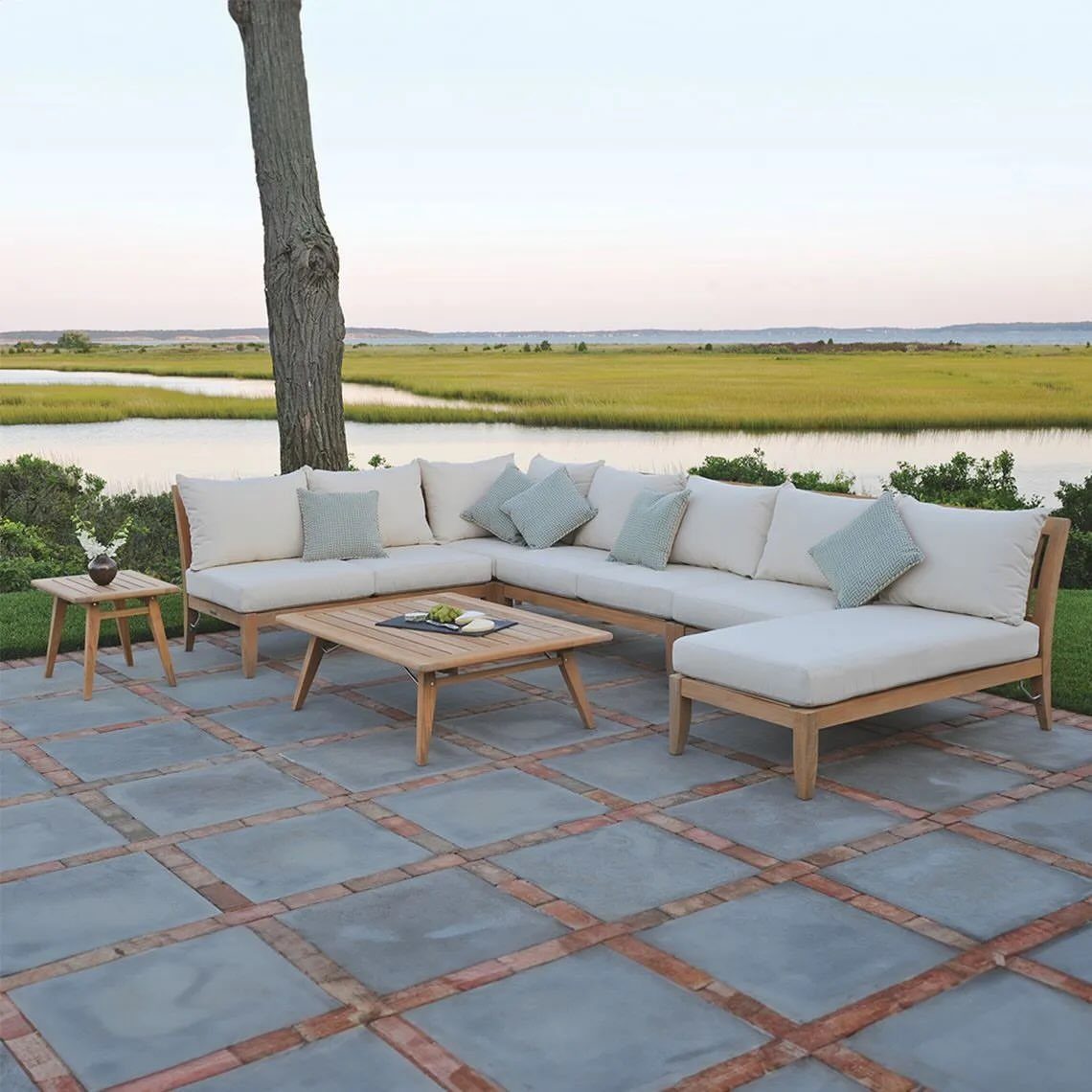 Outdoor Modular Seating: 20 Sectionals and Sofa Sets 8 L-shaped teak modular sectional with white cushions on a stone patio by water