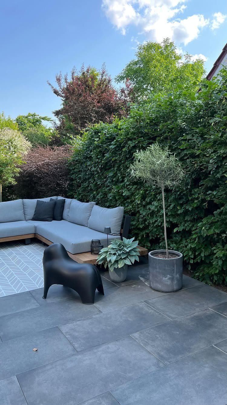 Outdoor Modular Seating: 20 Sectionals and Sofa Sets 16 Grey modular outdoor sectional sofa on a tiled patio with a black accent chair.