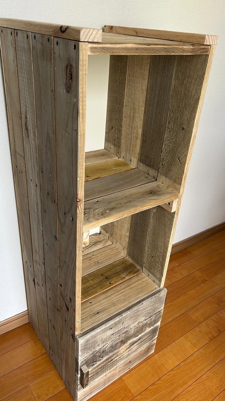 Rustic pallet wood bookshelf with two open shelves and a bottom drawer.
