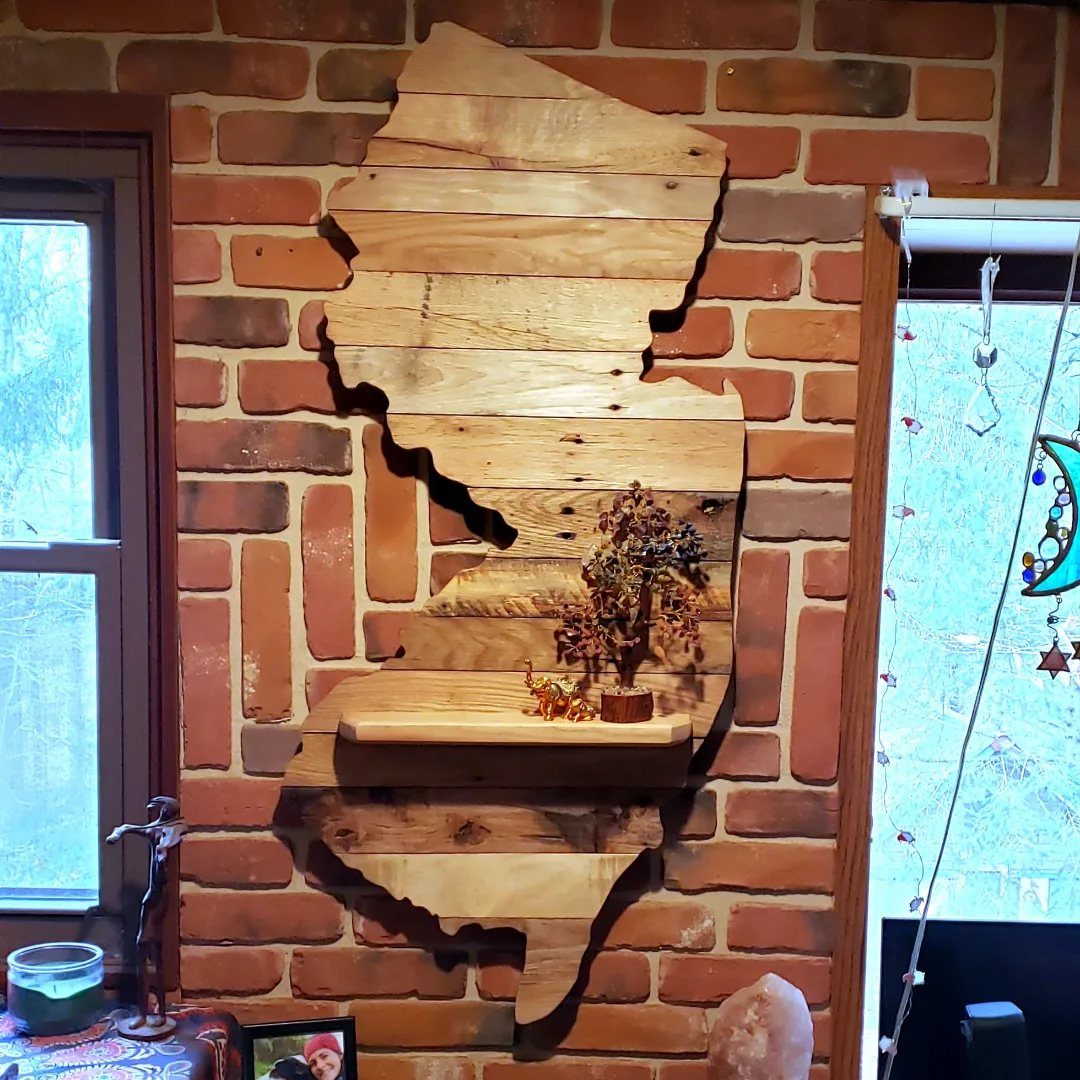 Wooden pallet art of Illinois state map mounted on a red brick wall.