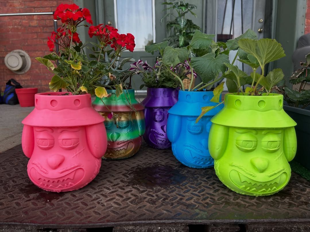 18 Unique Pots for Plants, From Resin Corgis to Copper Flowers 10 Colorful cartoon dog-shaped planters with green plants on a metal surface.