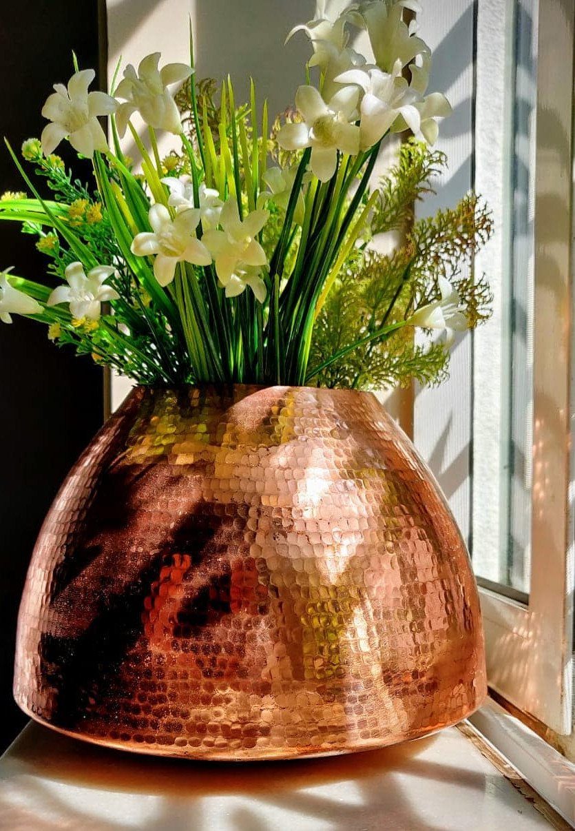 18 Unique Pots for Plants, From Resin Corgis to Copper Flowers 11 Hammered copper flower pot with white lilies on a sunny white windowsill