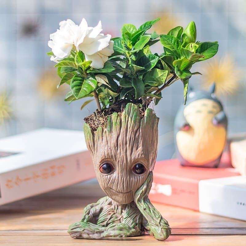 18 Unique Pots for Plants, From Resin Corgis to Copper Flowers 1 Groot man planter with a thinking pose holding a green plant with white flowers